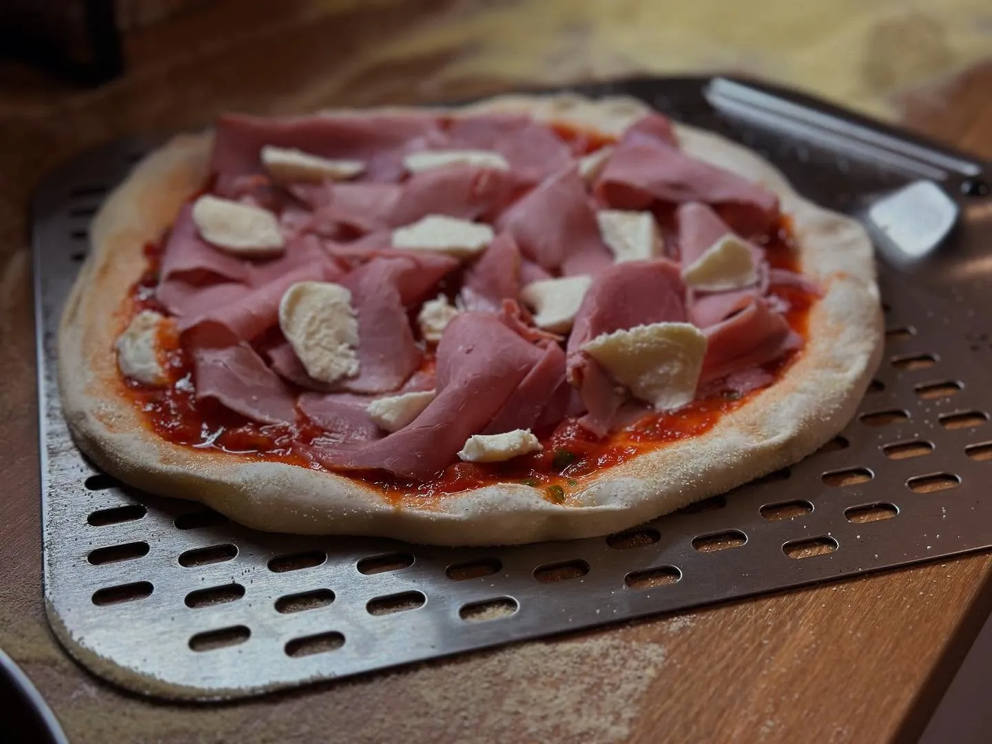 Thermomètre infrarouge pointé vers la pierre de cuisson de l'Ooni Koda 12 affichant 430°C — la température minimale avant d'enfourner